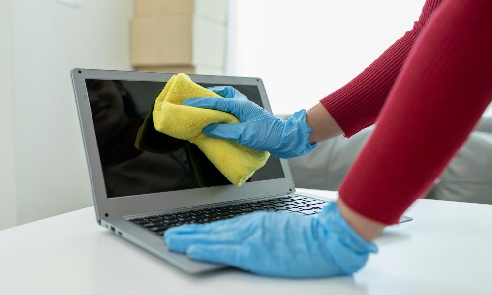 Janitor cleaning the office, Clean the notebook with a rag, wear gloves and wipe with a towel, Wear
